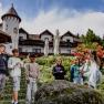Children play with a sword in a stone in front of a hotel.