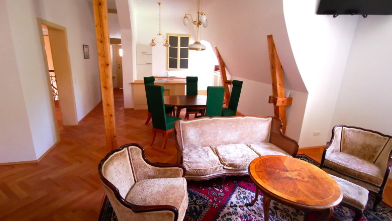 Living room with antique furniture and wooden beams.
