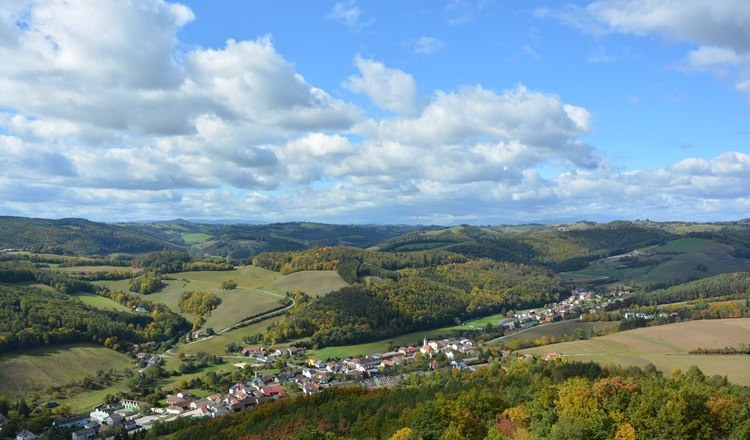 Landscape with hills, forests and a village in the fall.