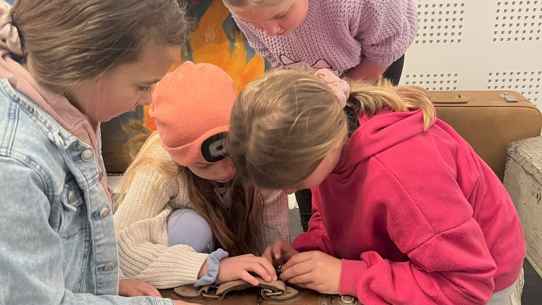 3 children try to open a suitcase