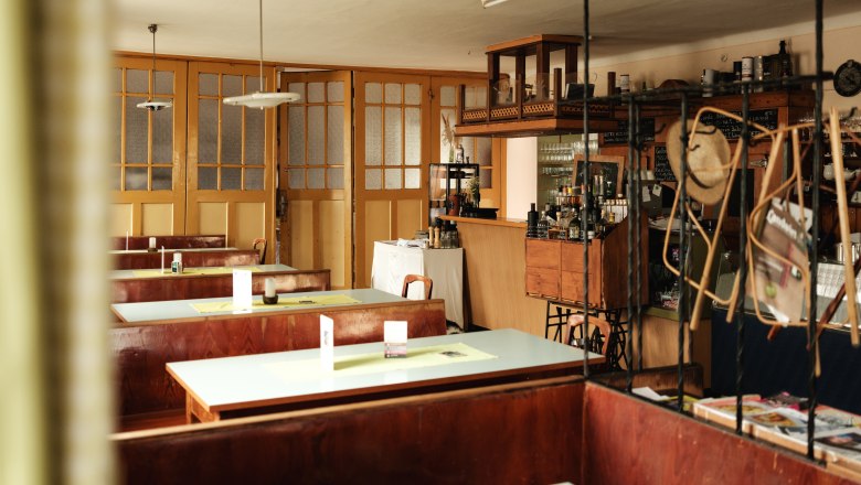 Interior view of a traditional inn with wooden tables and bar.