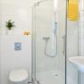 Modern bathroom with shower, toilet and washbasin.