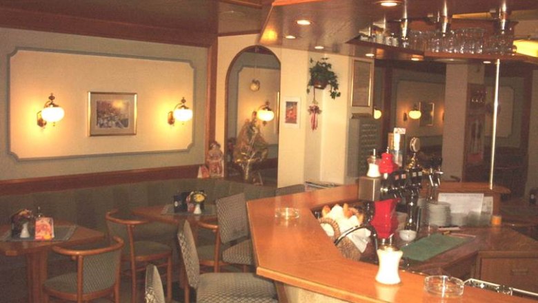 Interior view of a cozy caf&eacute; with wooden counters and seating areas.