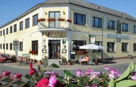 Exterior view of the Retzerlandhof with terrace and flowers.