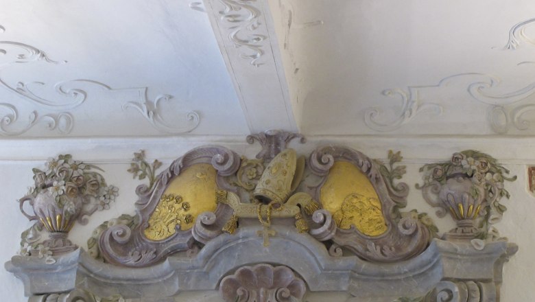 Baroque stucco decoration with floral motifs and golden elements on one ceiling.