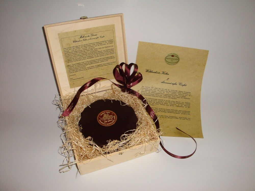 A decorative box with a round chocolate and an information sheet.