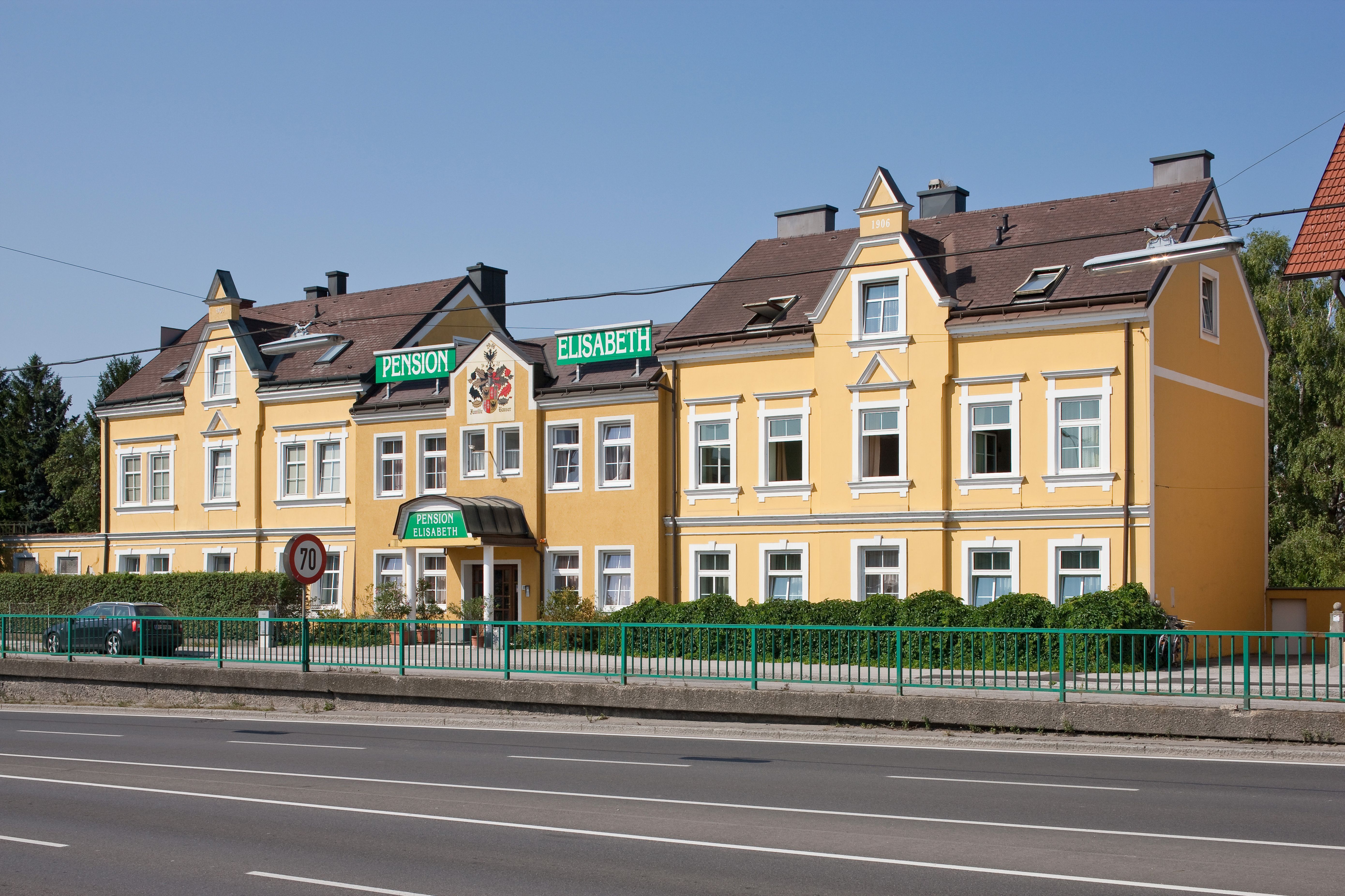 Yellow building of Pension Elisabeth with green signs.