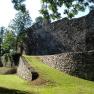 Old city wall with green area and trees in the sunlight.