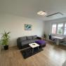 Living room with sofa, pictures on the wall and large window