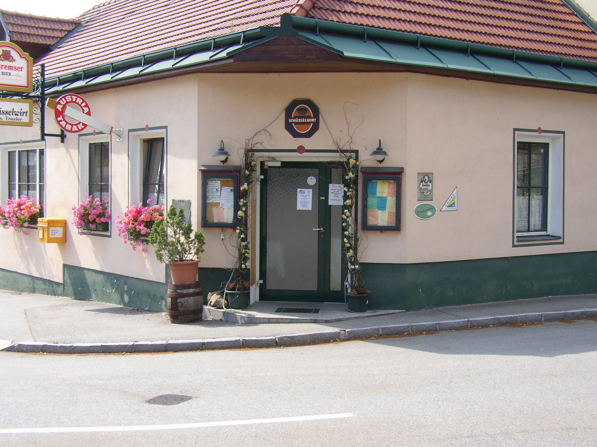 Entrance to a traditional inn with flowers and signs.