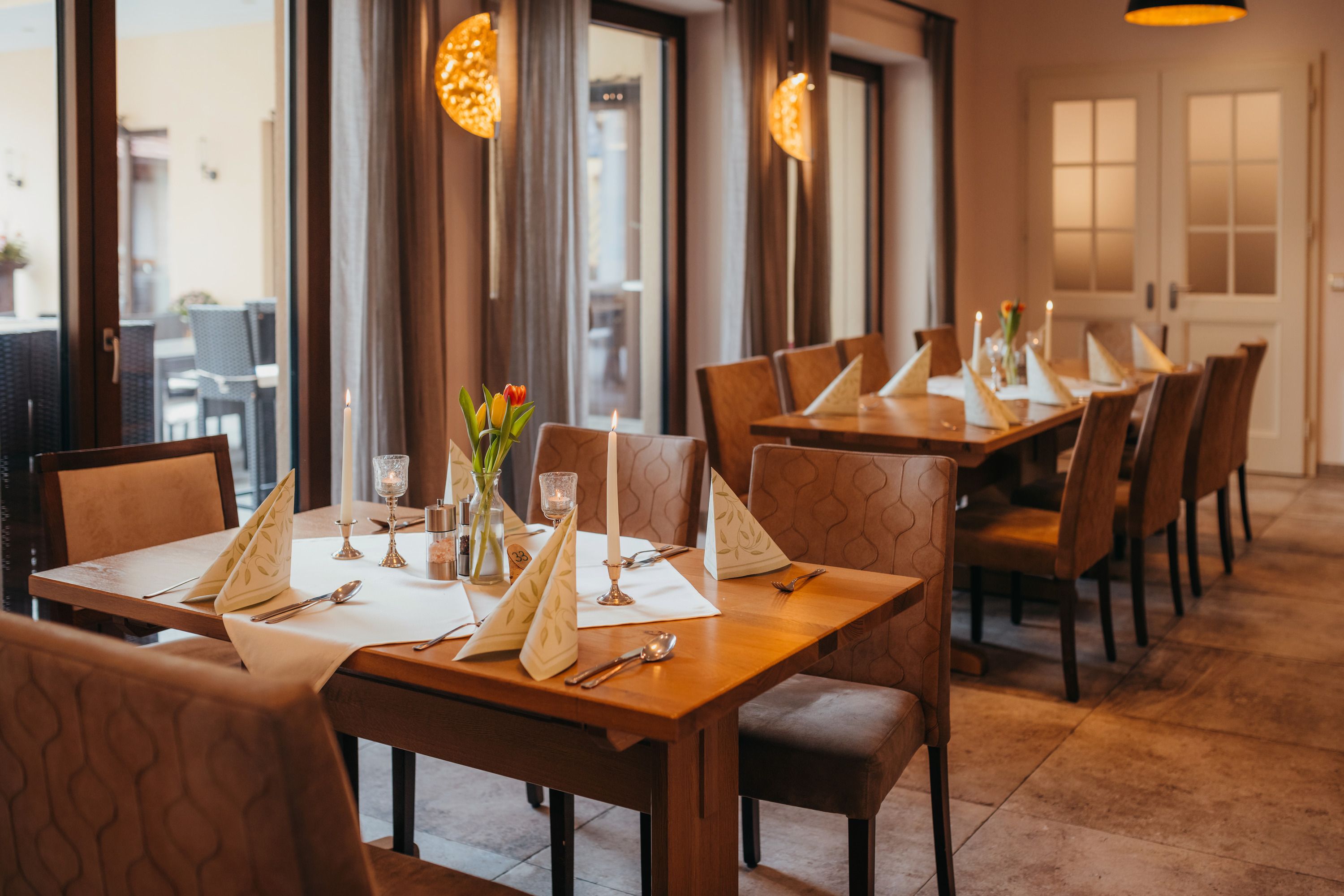A cozy table in an inn with candles and flowers.