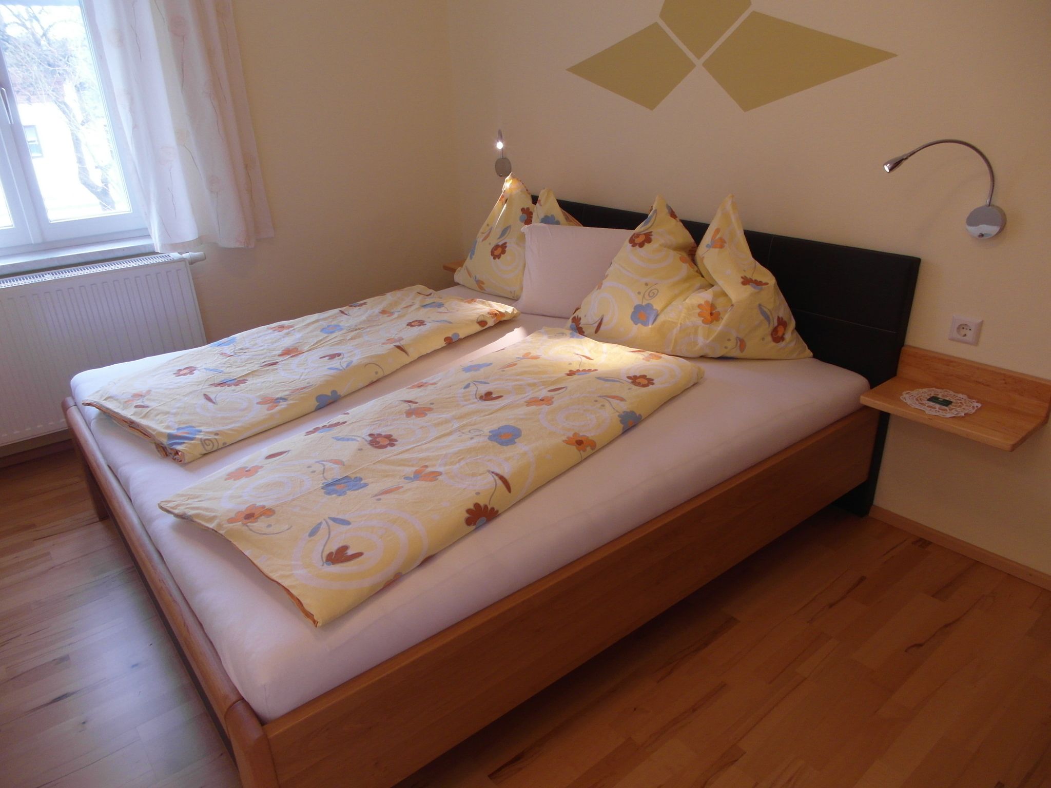 Cozy bedroom with double bed and yellow bed linen.