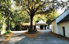 Idyllic square in Raschala with cobblestones, trees and white buildings.
