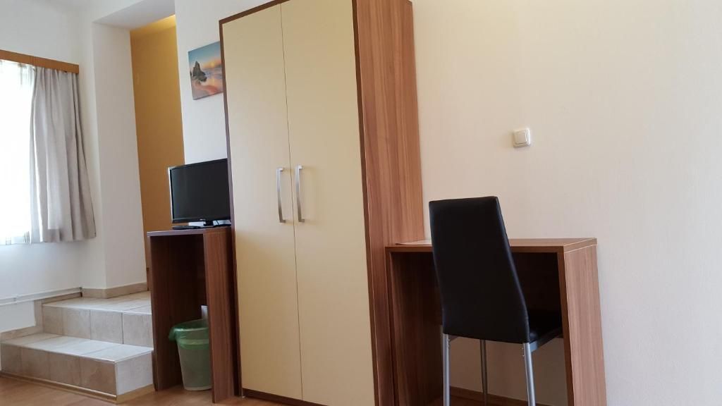 A simple room with a desk, chair, closet and small TV.