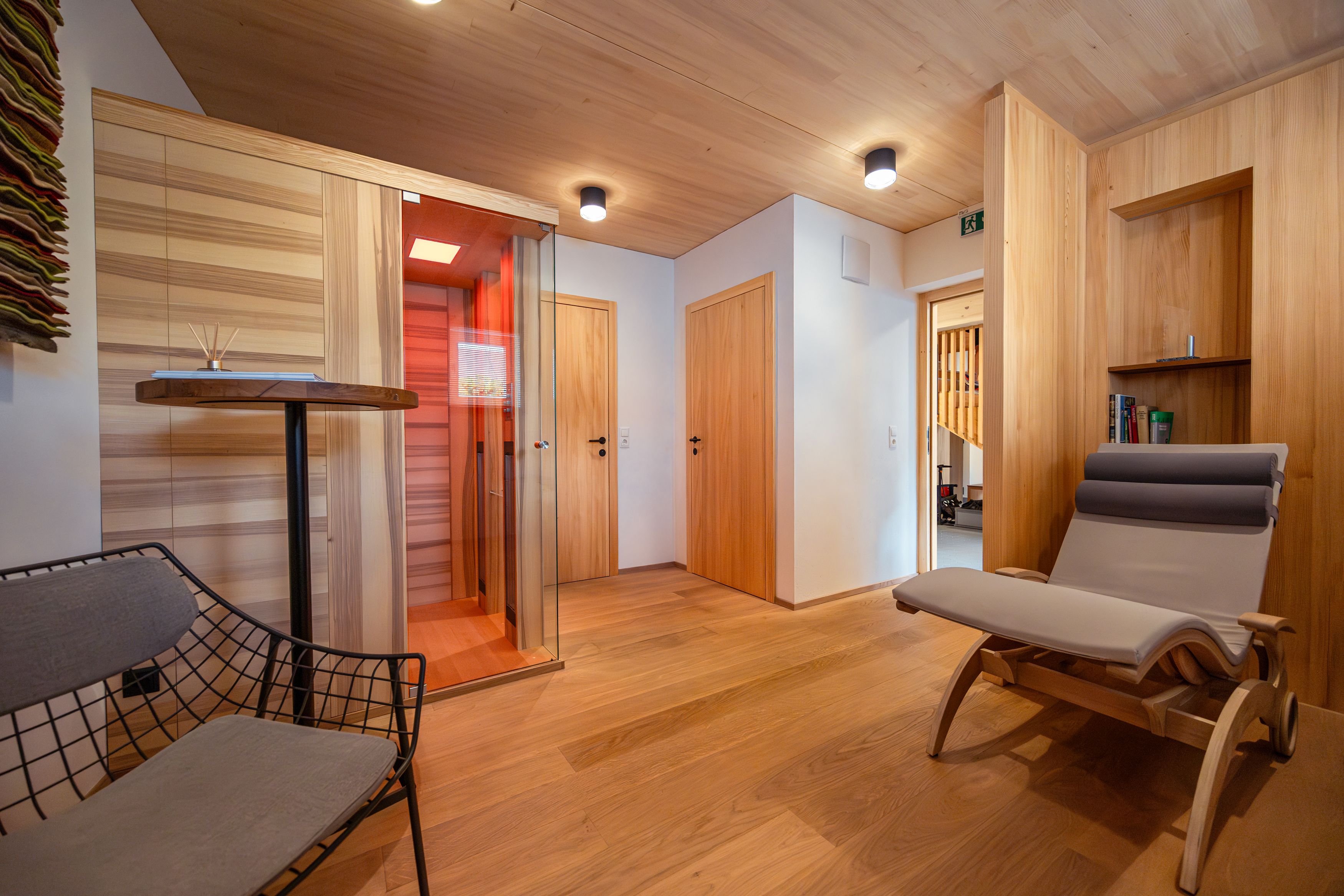 Interior view of a modern room with wood paneling, reclining chair and infrared cabin.