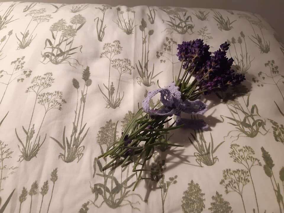 A bouquet of lavender lies on a cushion with a plant pattern.