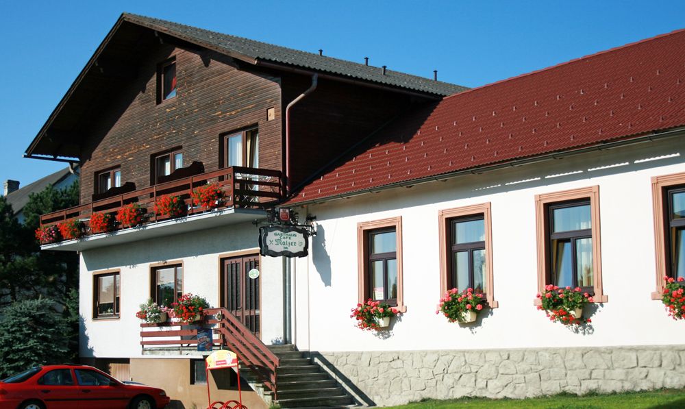 Gasthaus Malzer with flower-decorated balcony and windows.