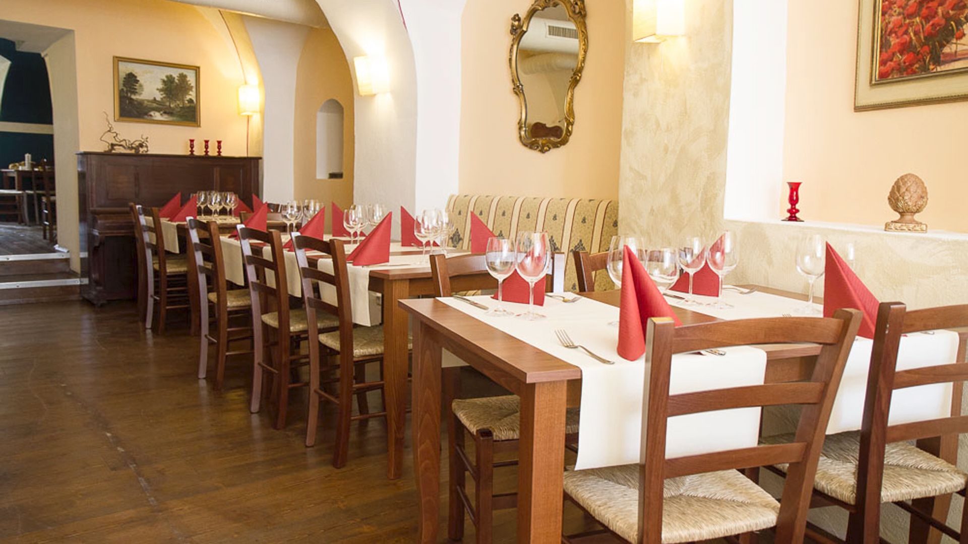 Elegant restaurant with laid tables and red napkins.