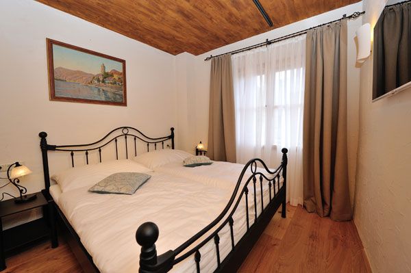 Bedroom with metal bed, wooden floor and painting on the wall.