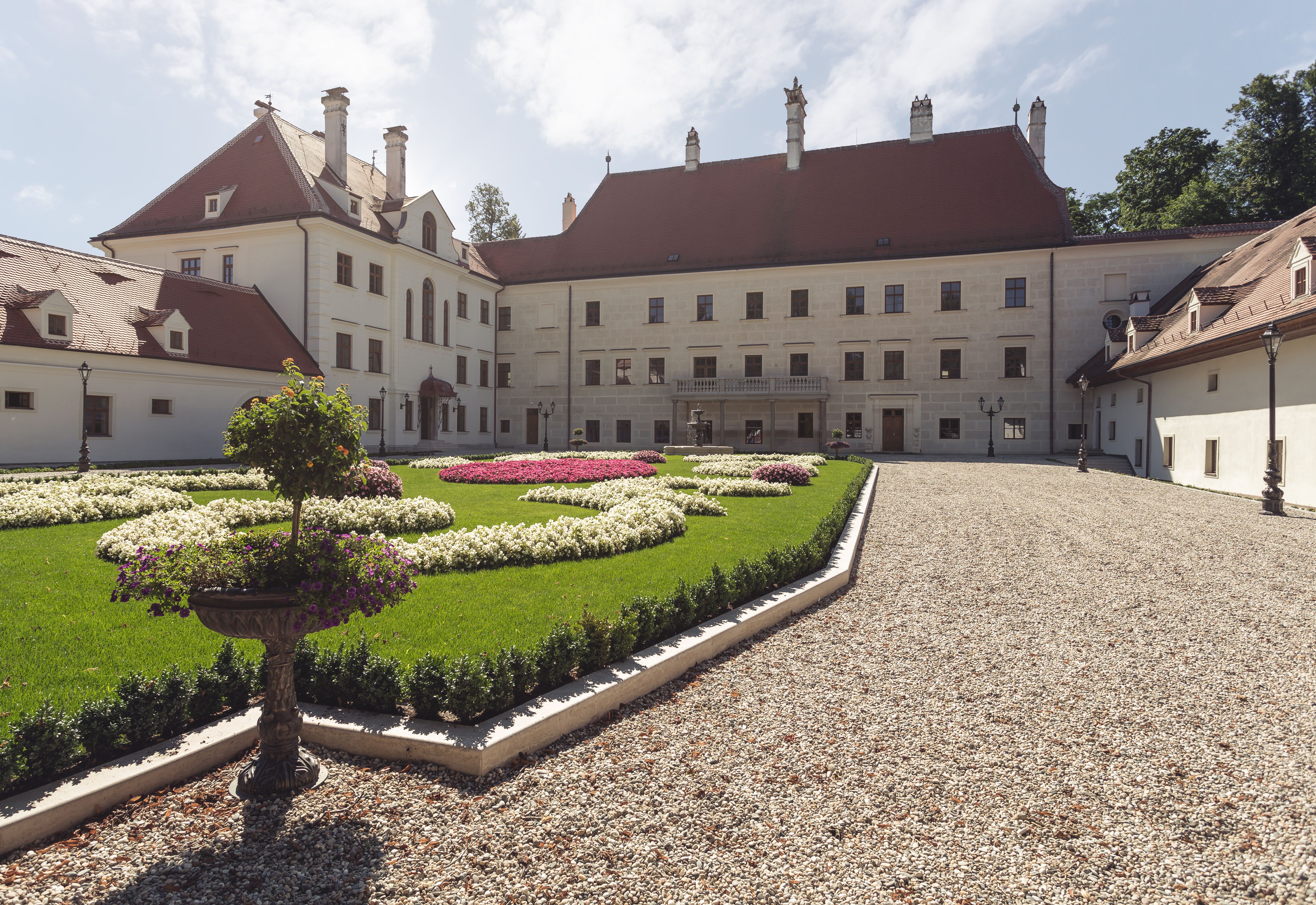 Schloss Thalheim with well-kept garden and gravel path.