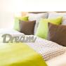Cozy bed with green and checkered bed linen, decorated with pillows and a 'Dream' lettering.