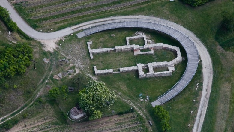 Aerial view of an archaeological excavation site with a semi-circular footbridge.