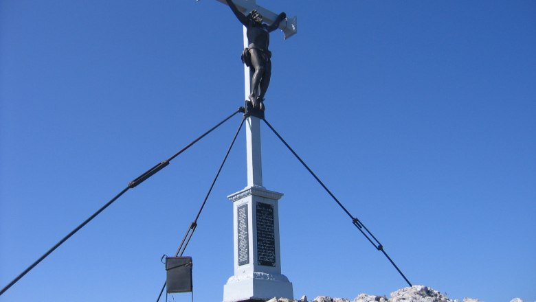 Töpper cross on the summit of Dürrenstein against a blue sky.