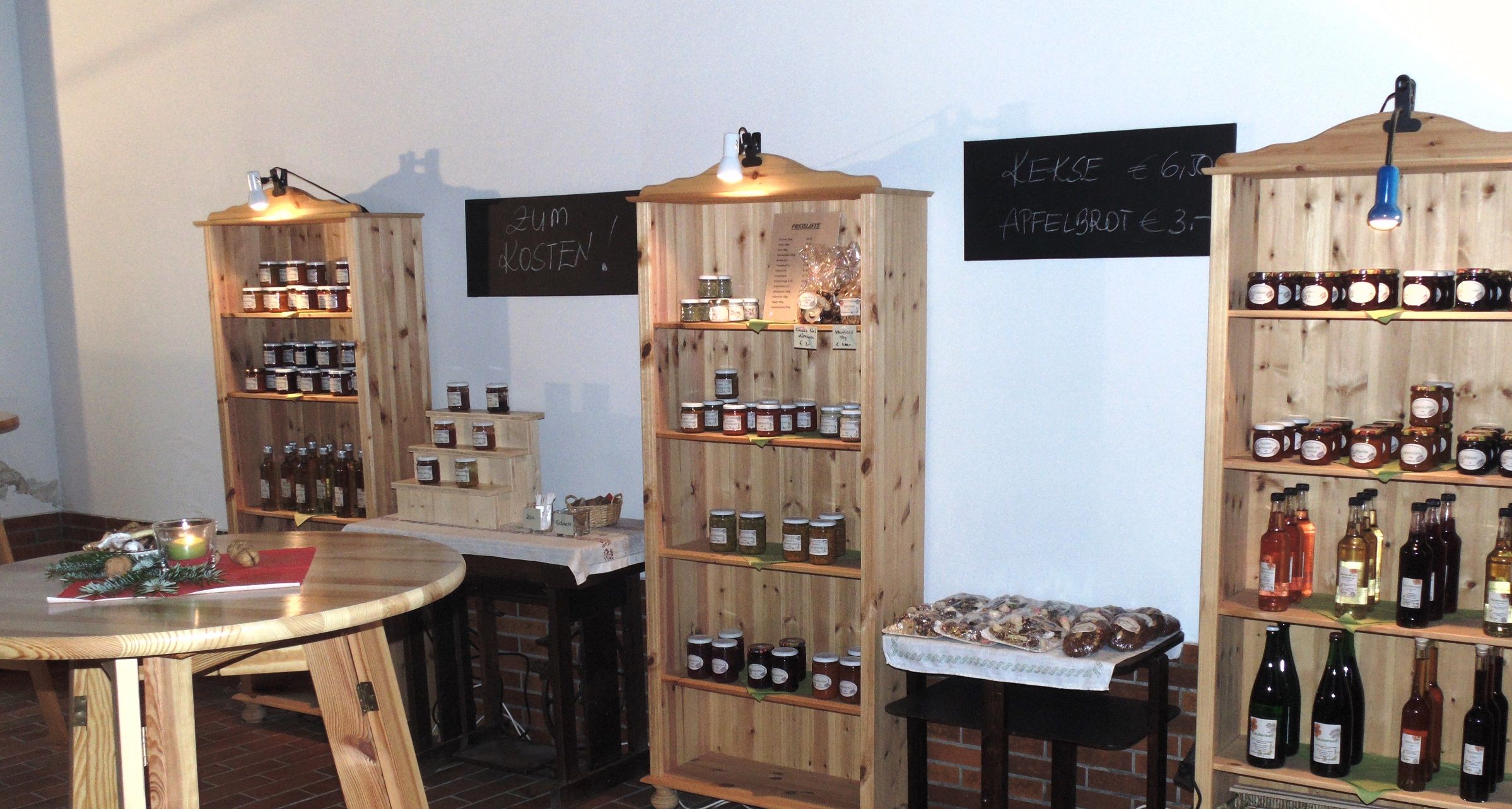 Interior view of a farm store with shelves full of jams, juices and cookies.