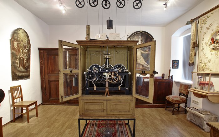 Interior view of a museum room with antique clock and historical furniture.