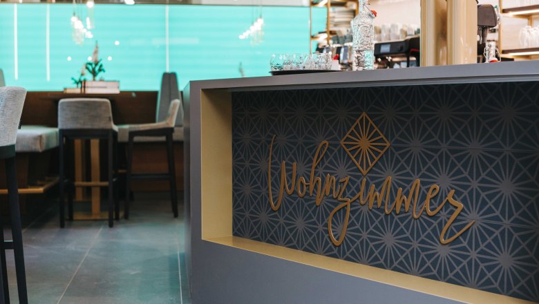 Interior view of a caf&eacute; with the lettering 'Wohnzimmer' on a counter.