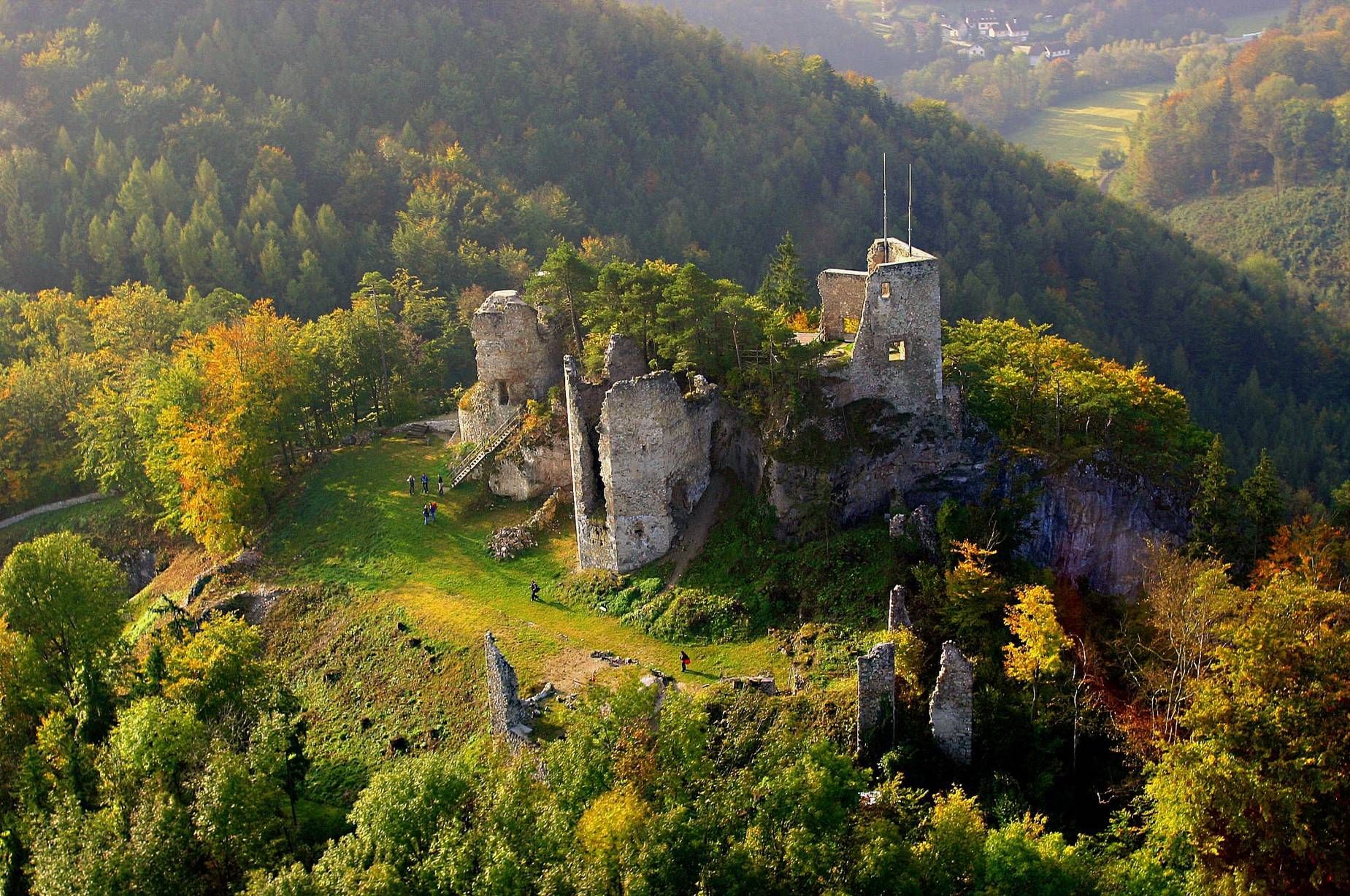Aerial view of the Rabenstein castle ruins surrounded by forest in the fall.