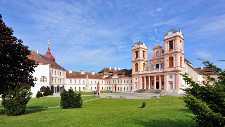 G&ouml;ttweig Abbey with its baroque architecture and green forecourt under a blue sky.