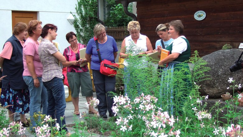 Group of women in a herb garden listening to a guided tour.