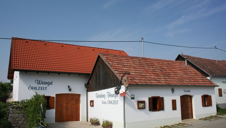 Exterior view of a traditional wine tavern with white walls and red tiled roofs.