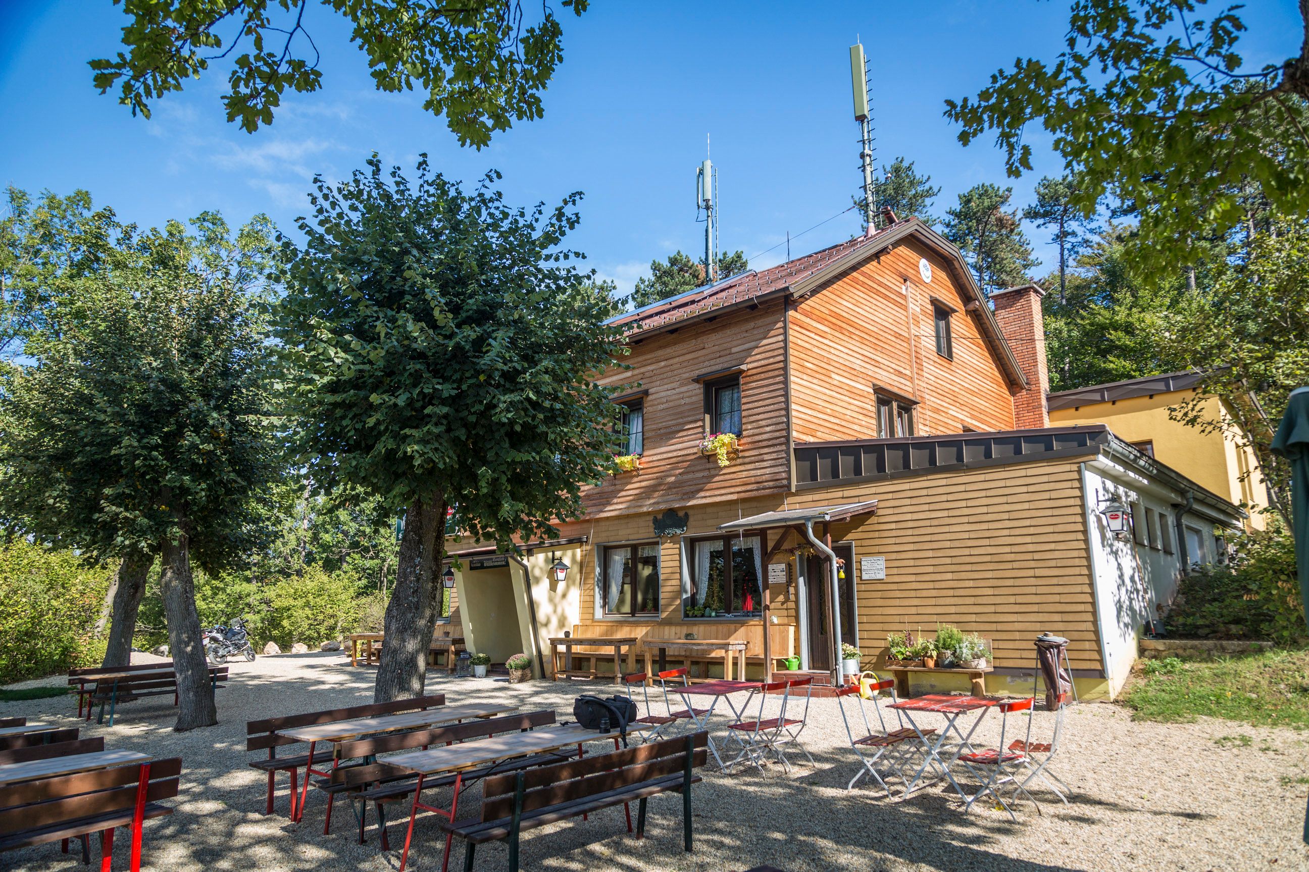 Wooden house with outdoor beer garden surrounded by trees.