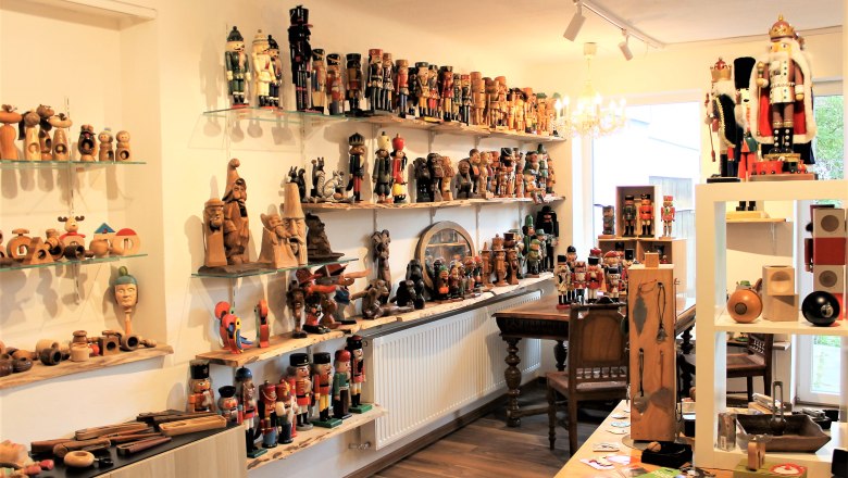 A room full of nutcrackers and wooden figures on shelves and tables.
