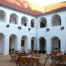 Inner courtyard of the Eisenhuthaus with arcades and wooden furniture.