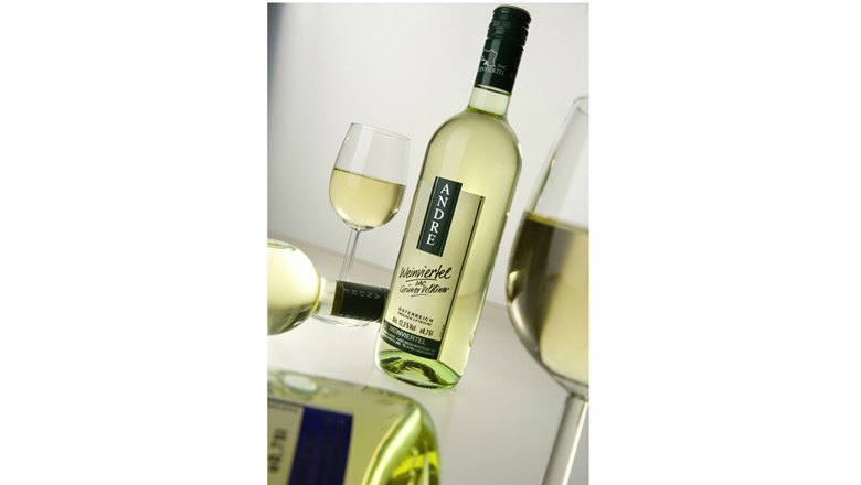 White wine bottle with glass on a table.