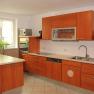 Modern kitchen with wooden cupboards, sink, stove and microwave.