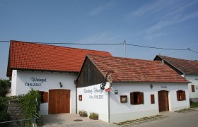 Exterior view of a traditional wine tavern with white walls and red tiled roofs.