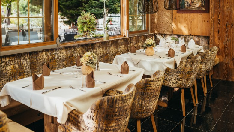 Cozy restaurant with laid tables, flowers and rustic ambience.