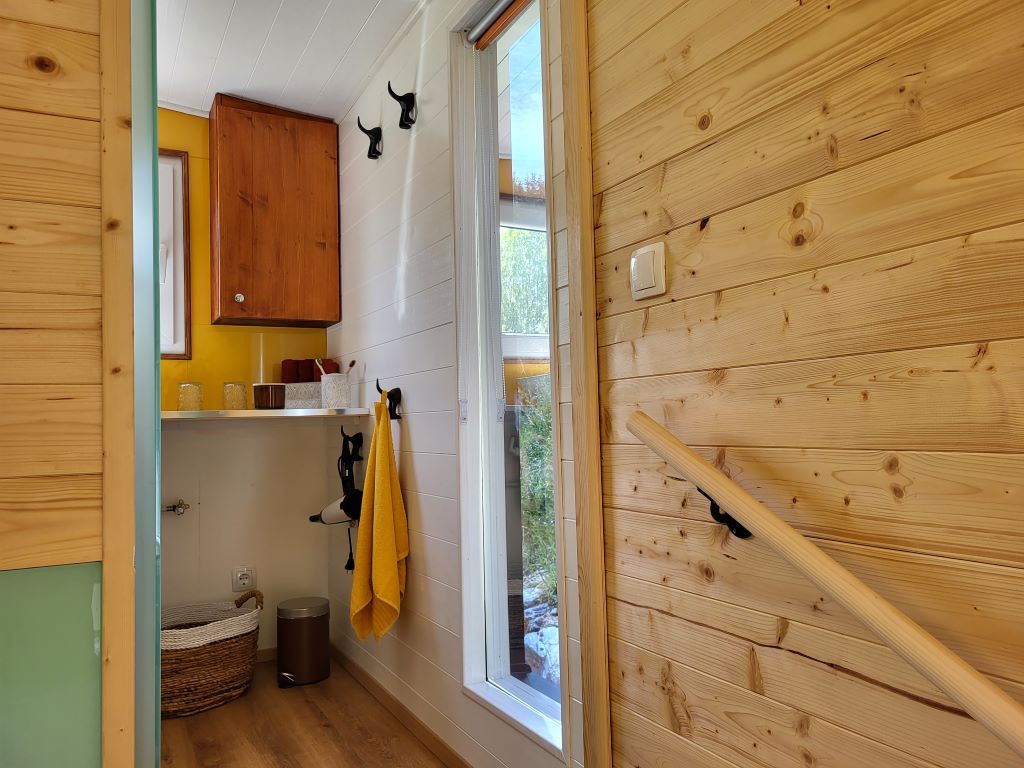 Interior view of a bathroom with wood paneling and yellow accents.