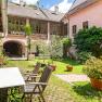 Inner courtyard with garden furniture, plants and pink building in the background.