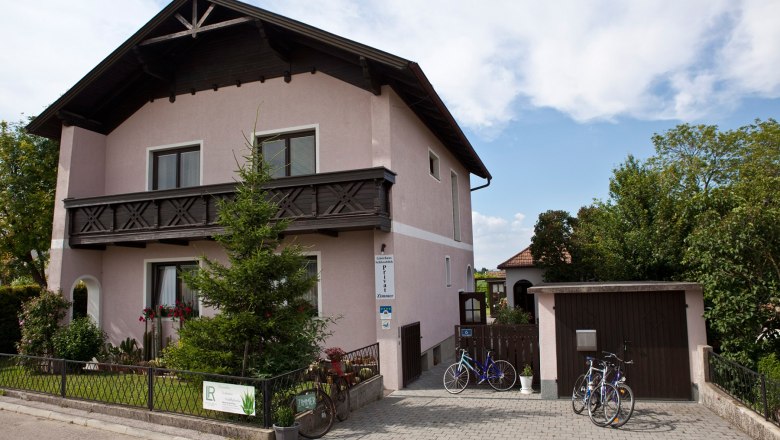 Straßenansicht des Hauses mit gepflegtem Vorgarten und Einfahrt mit Garage.