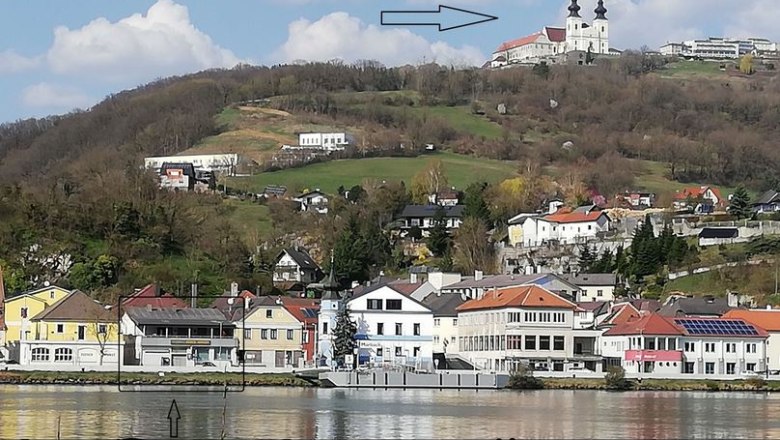 View of Maria Taferl with church on a hill, below the village and a sign for the Steindl bike store.