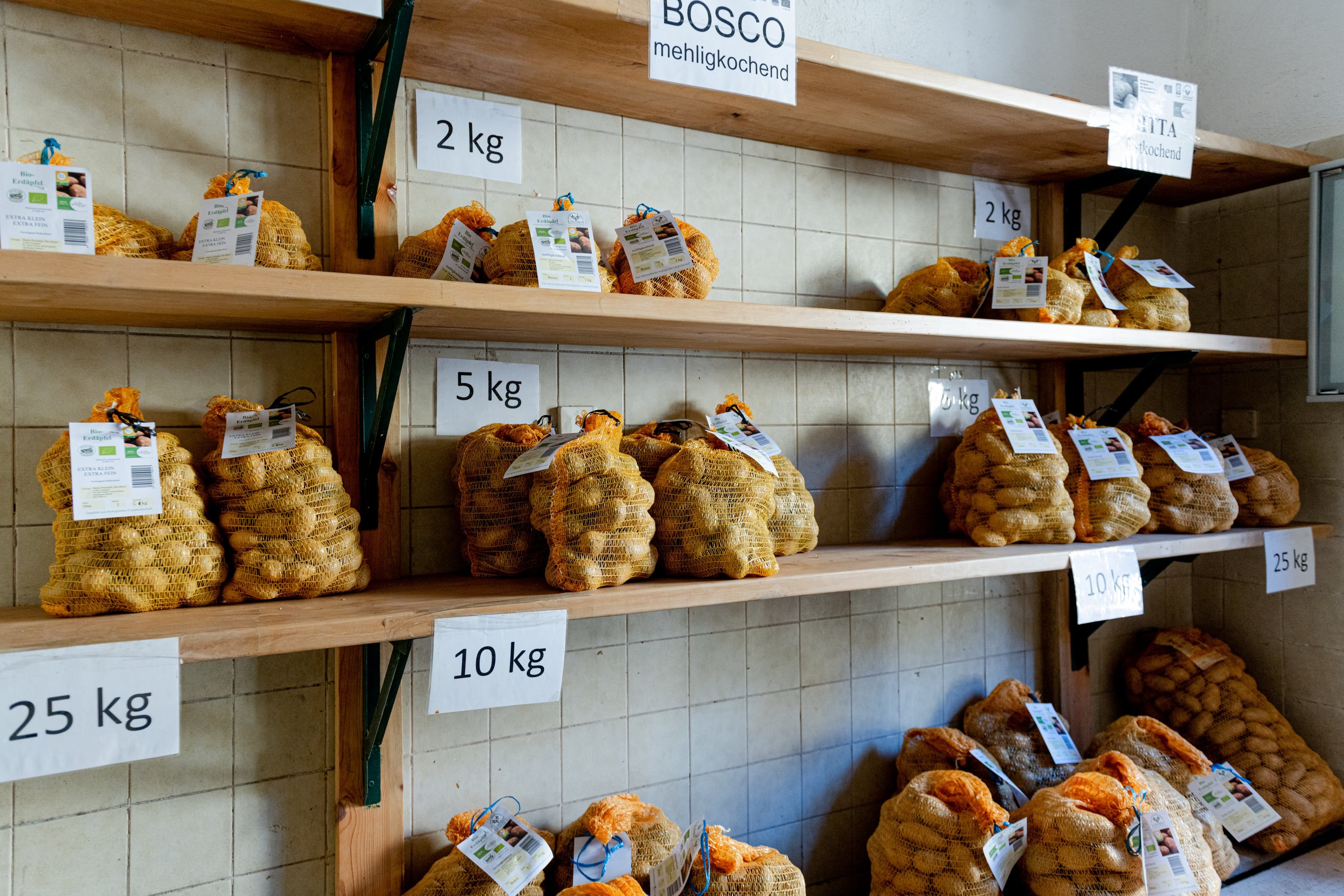 Sales room with shelves of potato sacks in various weight units.