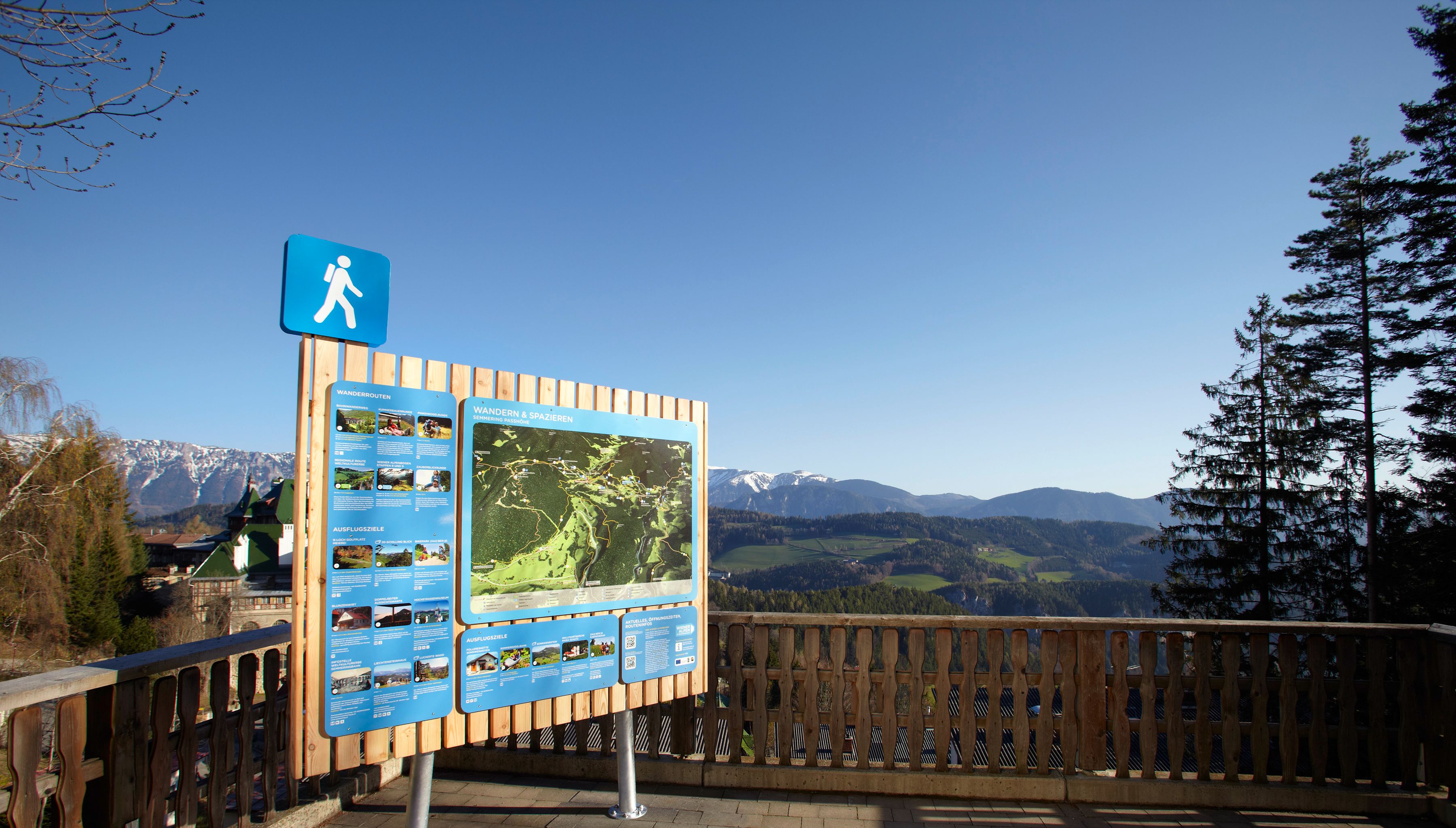 Hiking starting point Semmering with information board and mountain landscape in the background.