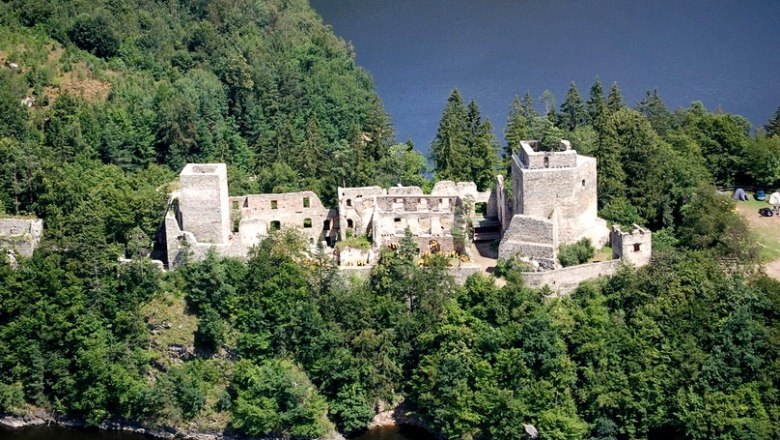 Aerial view of the Dobra ruins, surrounded by forest and water.