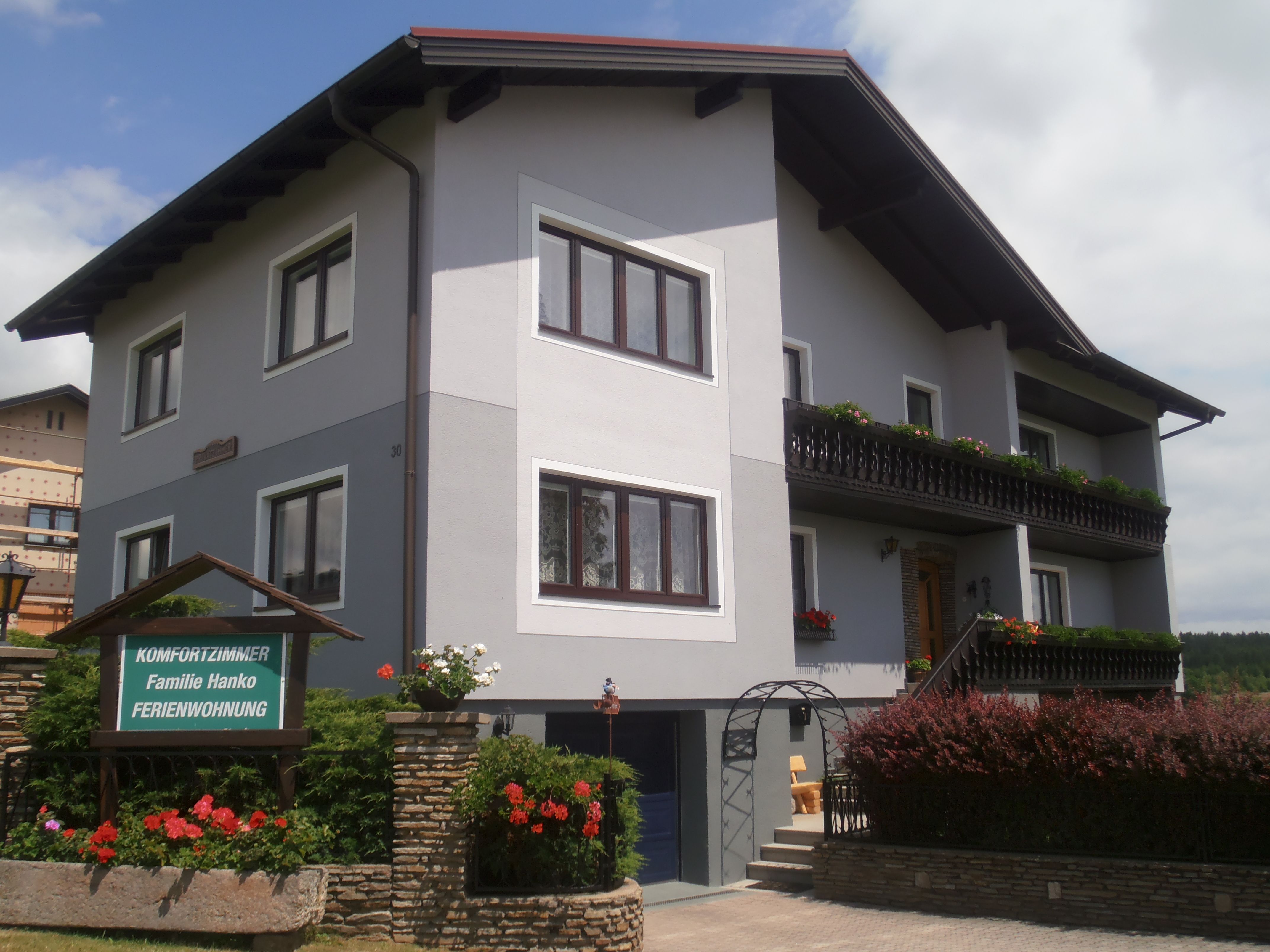 A two-storey guest house with balcony and garden.
