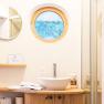 Modern bathroom with round window and washbasin.
